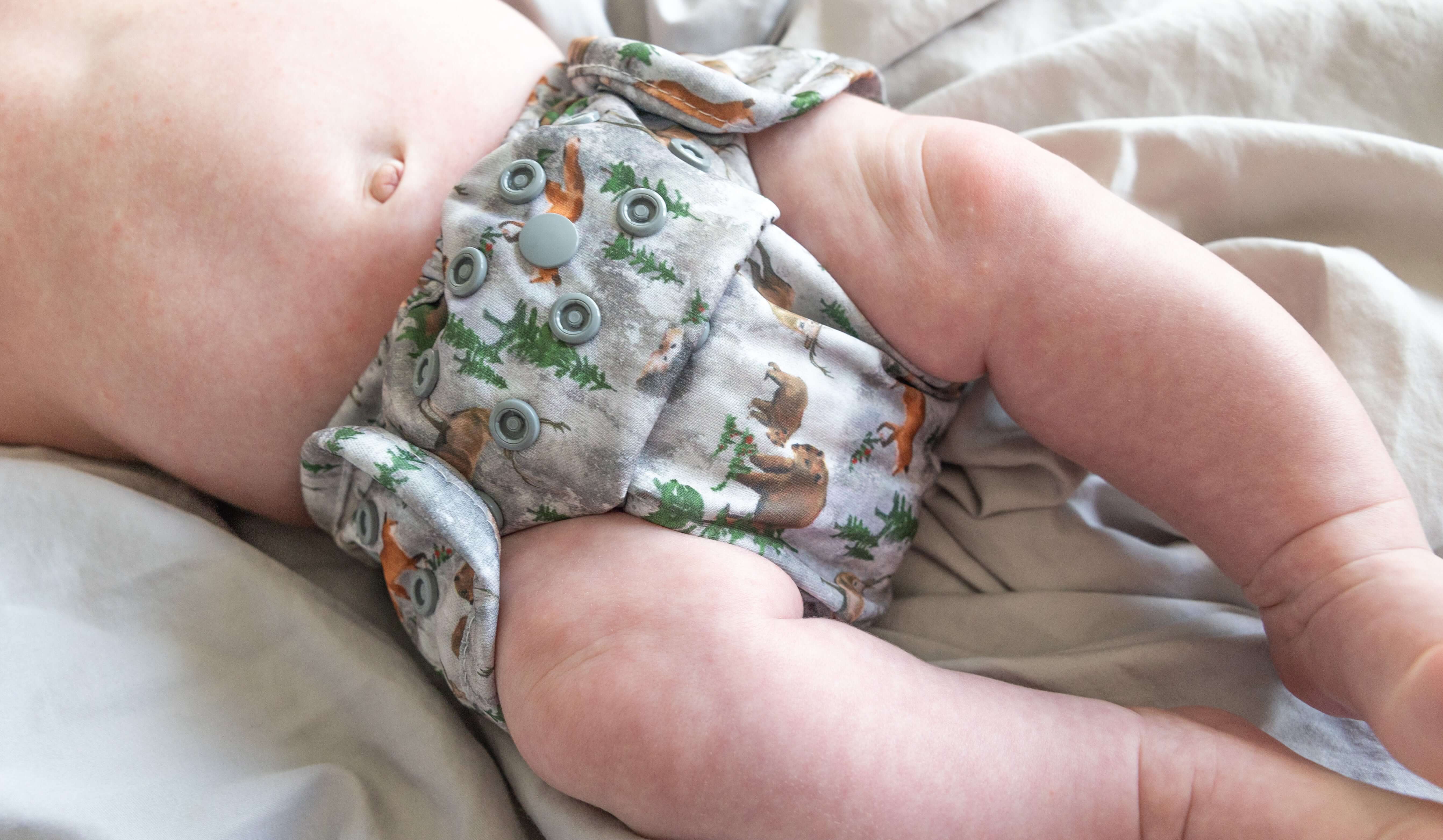 A baby wearing a Bayrli Outer cloth diaper cover